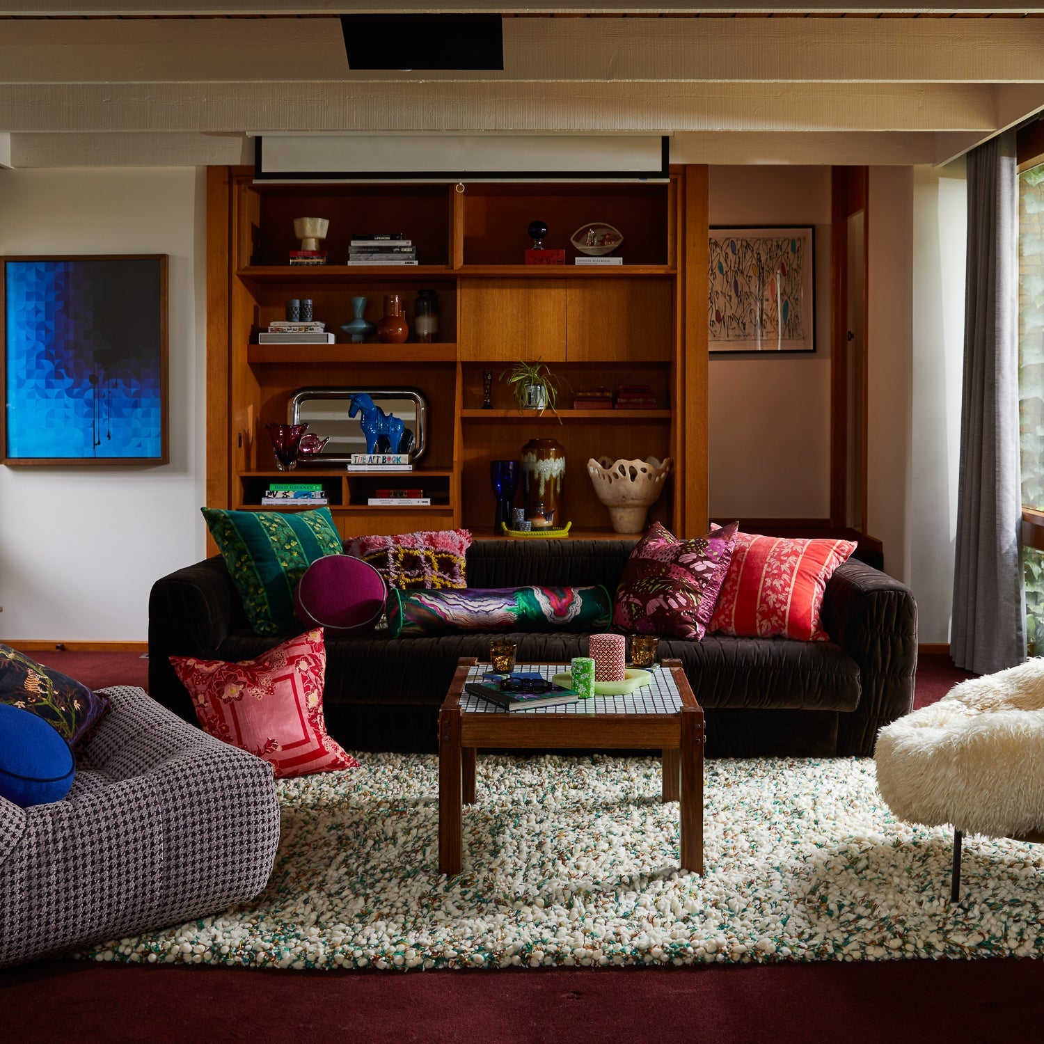 Wide room view showing Eliza Cushion in mid-century modern living space with built-in shelving