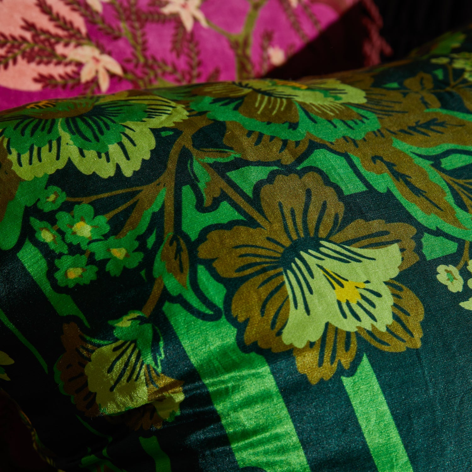 Close-up detail of silk-linen fabric texture showing verdant floral pattern and lustrous finish