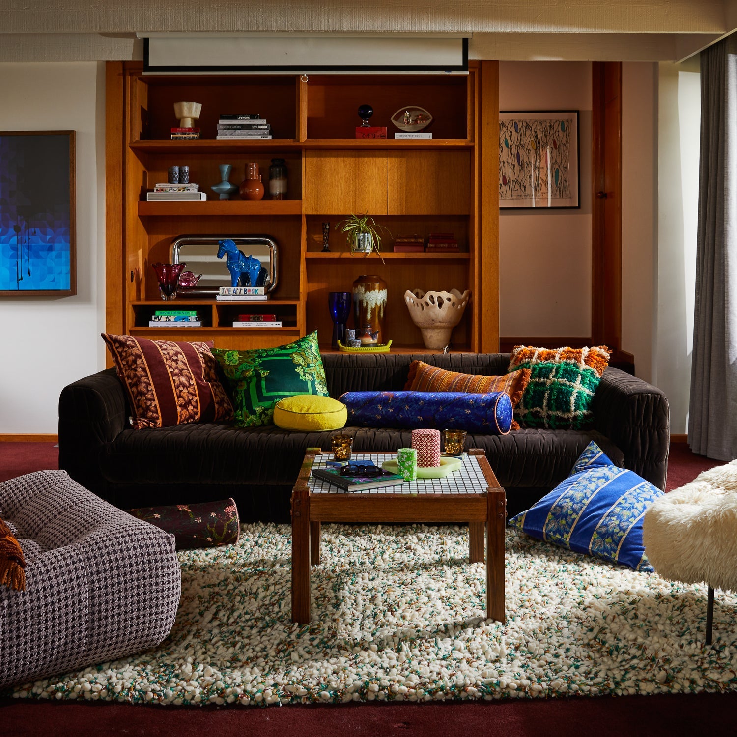 Living room styling with Eliza Cushion layered among colorful decorative pillows on modern sofa