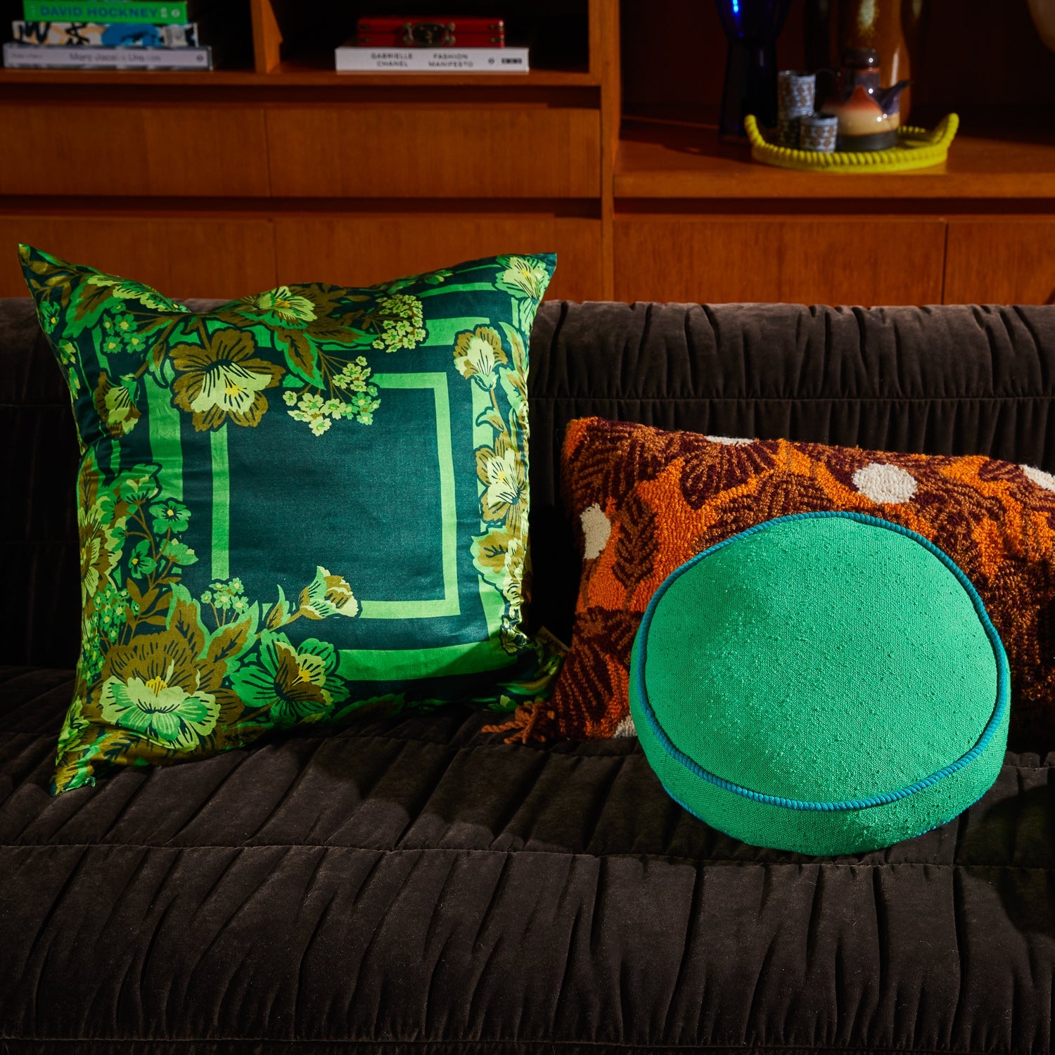 Eliza Cushion styled with contrasting orange and green pillows showing layered home decor arrangement