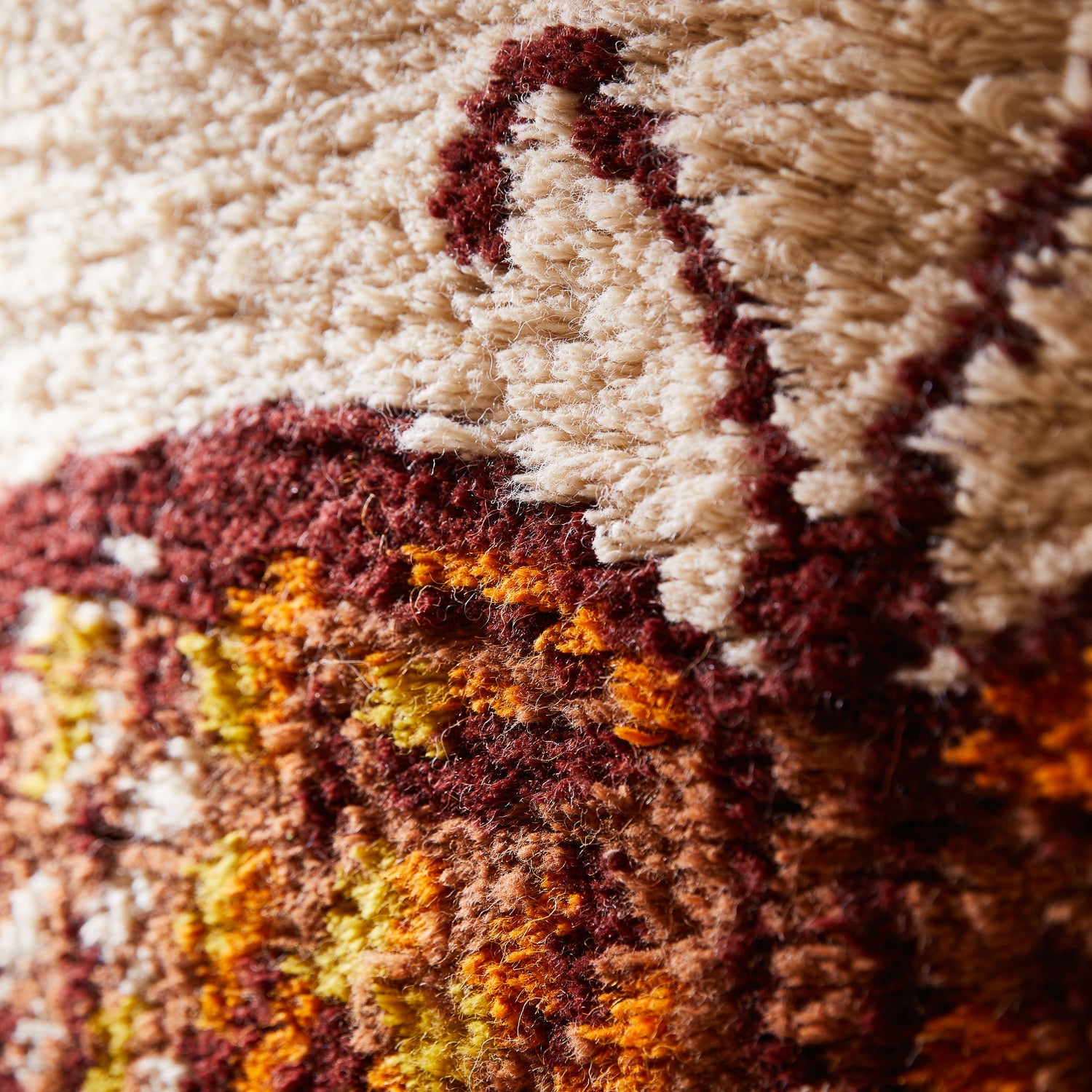 Close-up detail of textured fabric showing orange burgundy and cream fibers in butterfly wing pattern