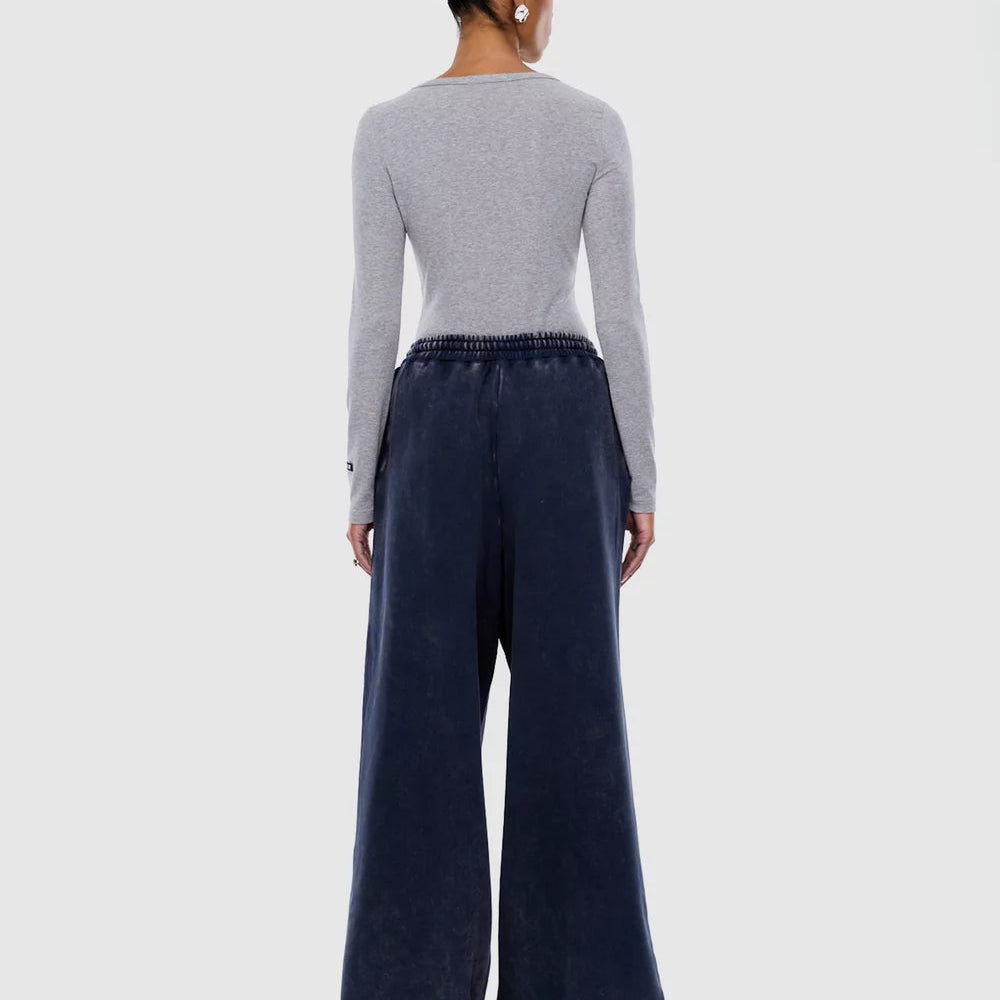 Back view of washed ink track pants showing elastic waistband and relaxed wide leg fit