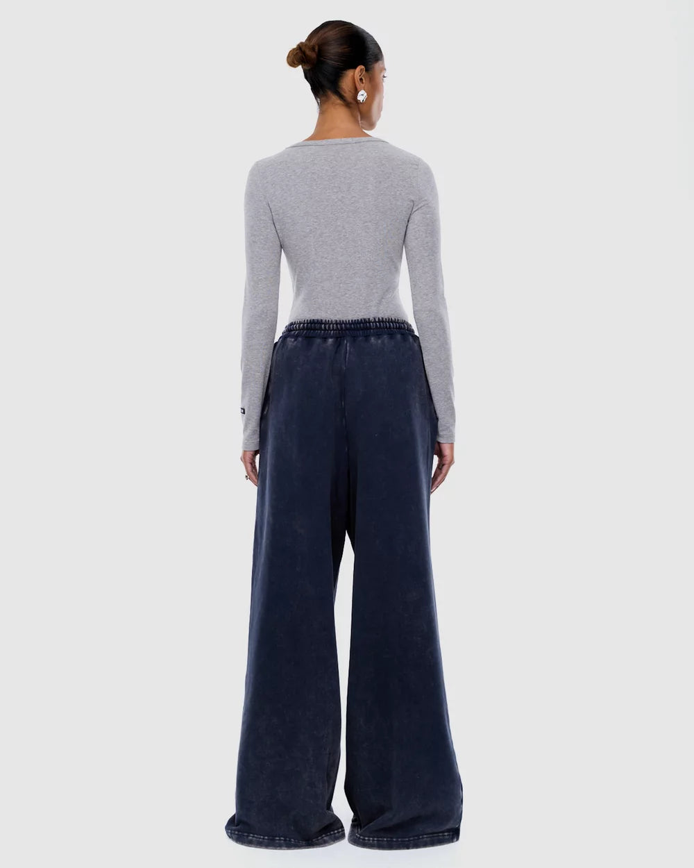 Back view of washed ink track pants showing elastic waistband and relaxed wide leg fit