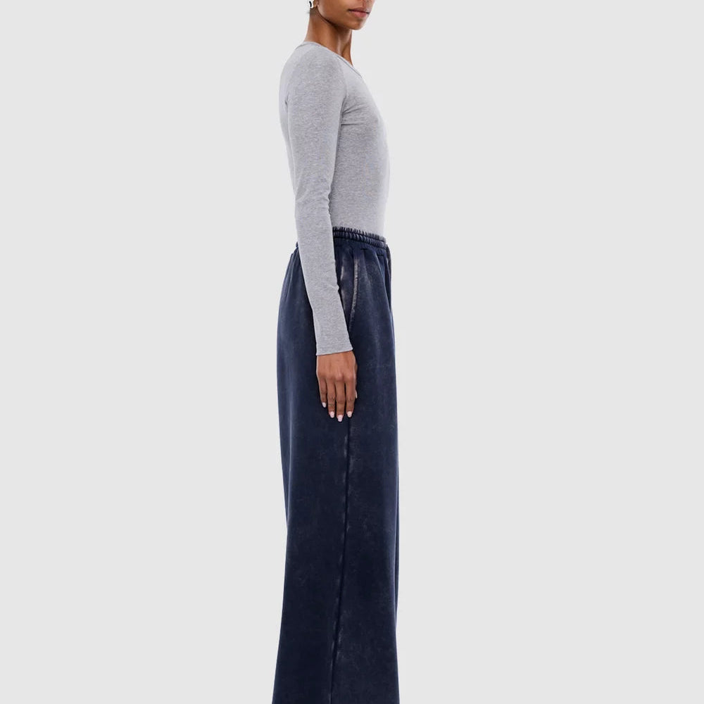 Profile view of washed ink track pants showing loose fit and elastic waistband detail