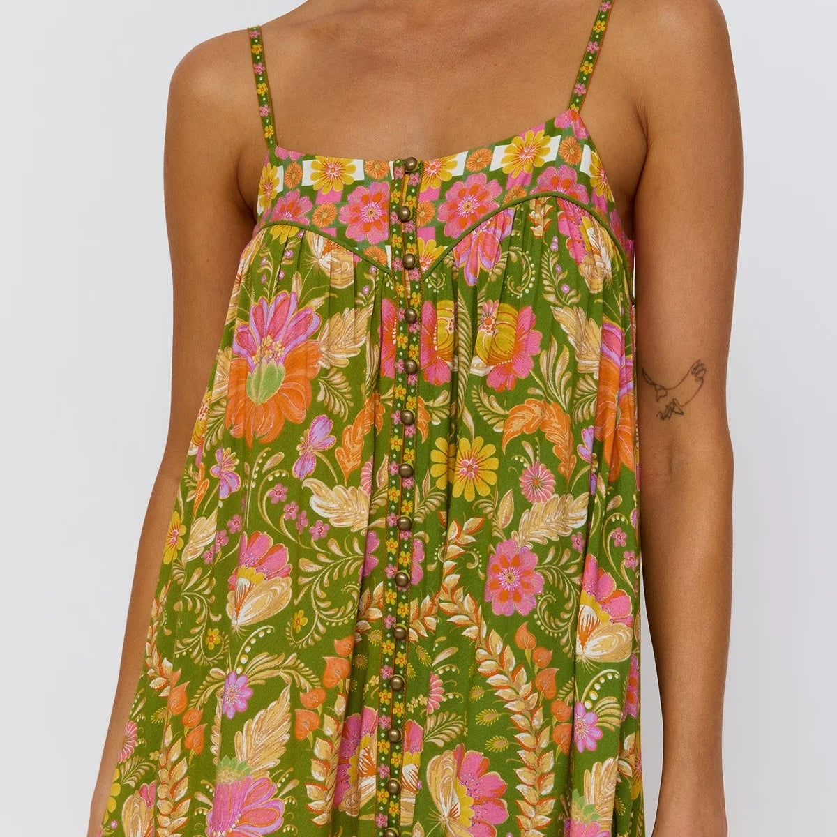 Close up detail of brass dome buttons and shaped yoke with piping on Estella dress guava colorway