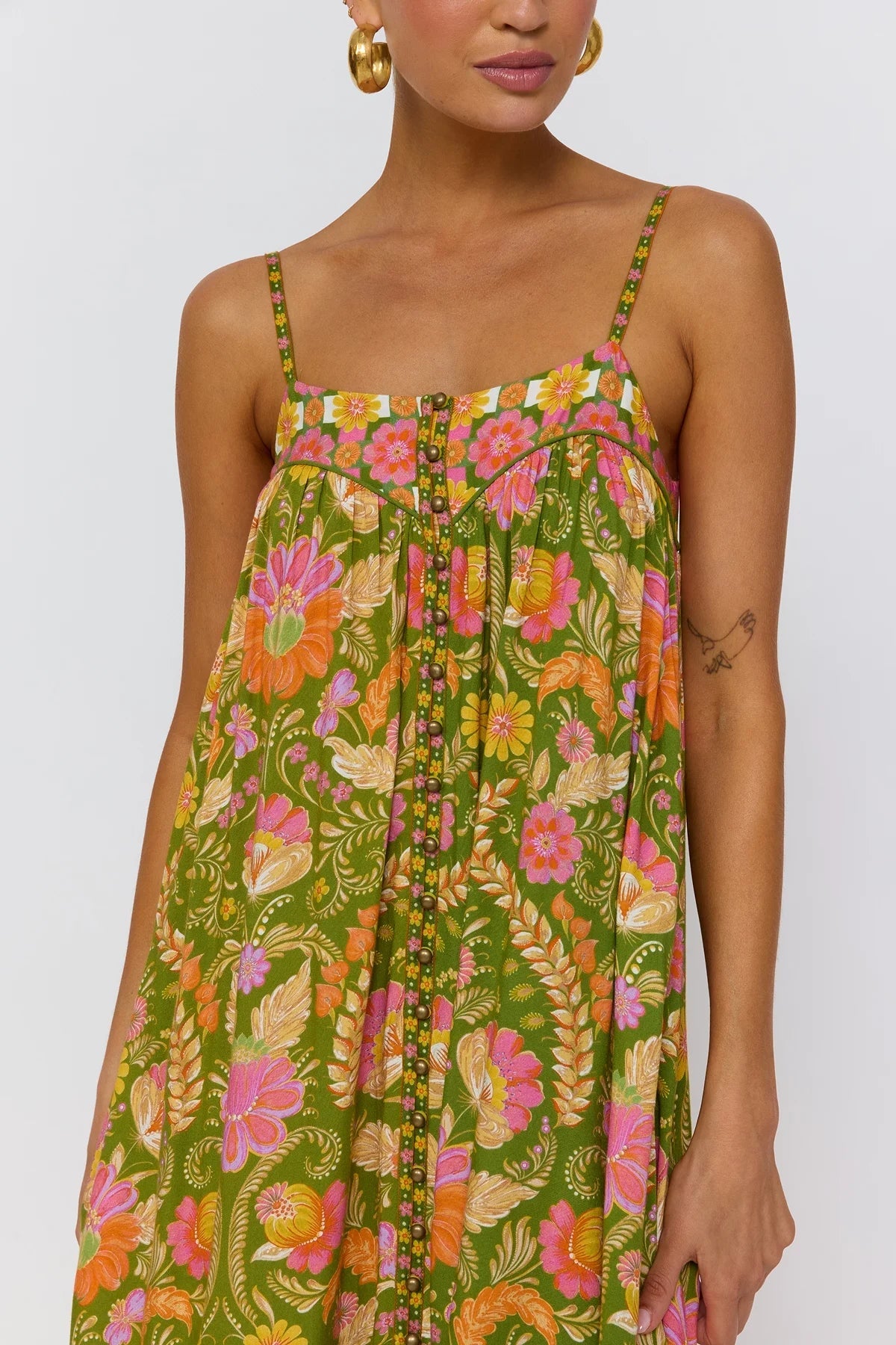 Close up detail of brass dome buttons and shaped yoke with piping on Estella dress guava colorway