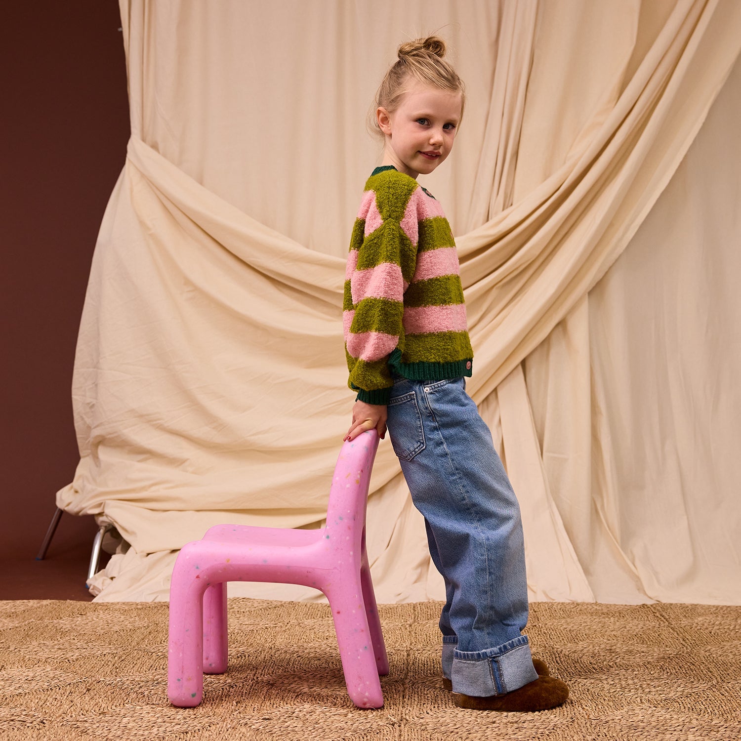 Side profile of child in Estrid Kids Cardigan showing relaxed drop shoulder fit and shaped sleeves