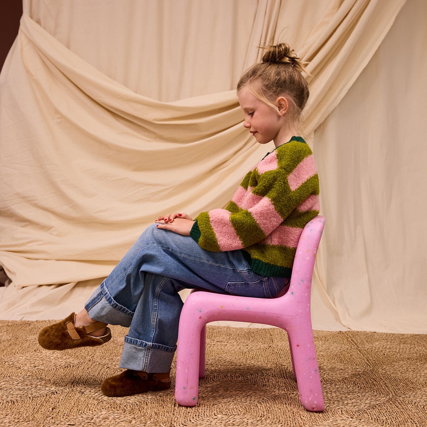 Side view of seated child wearing Estrid Kids Cardigan showing comfortable fit and everyday wear styling