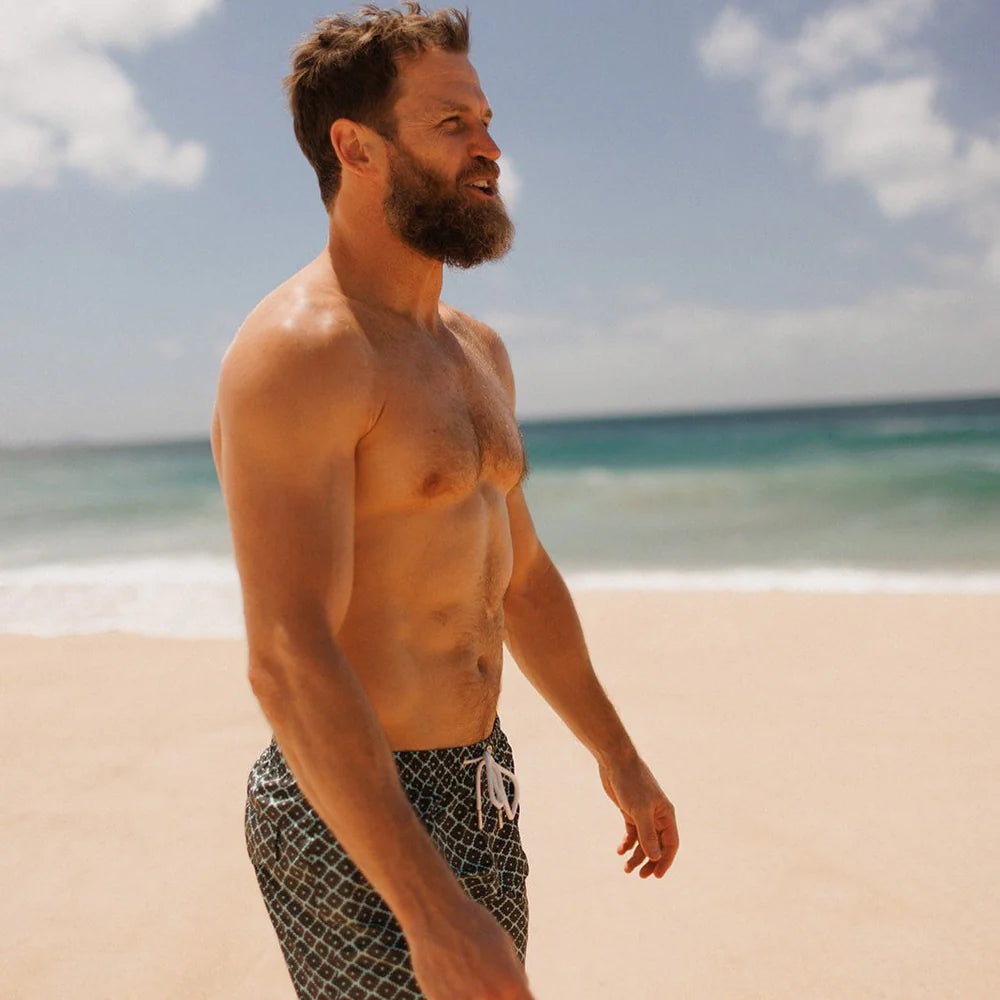 man at beach wearing Evergreen diamond swim shorts by Swim Shady