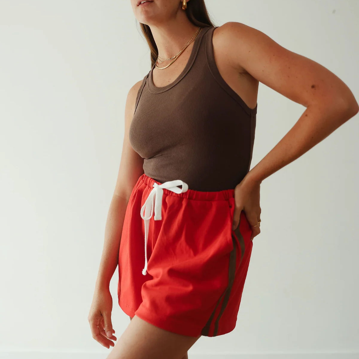 Red shorts with brown stripe by By Billie