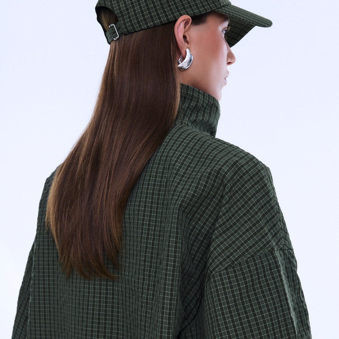 Side profile view of Fallon Check Cap showing curved brim and olive green check fabric detail