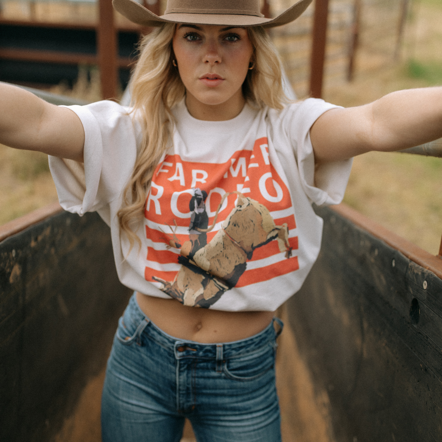 Front view of Rodeo Box Tee showing orange and white rodeo graphic with bull rider design
