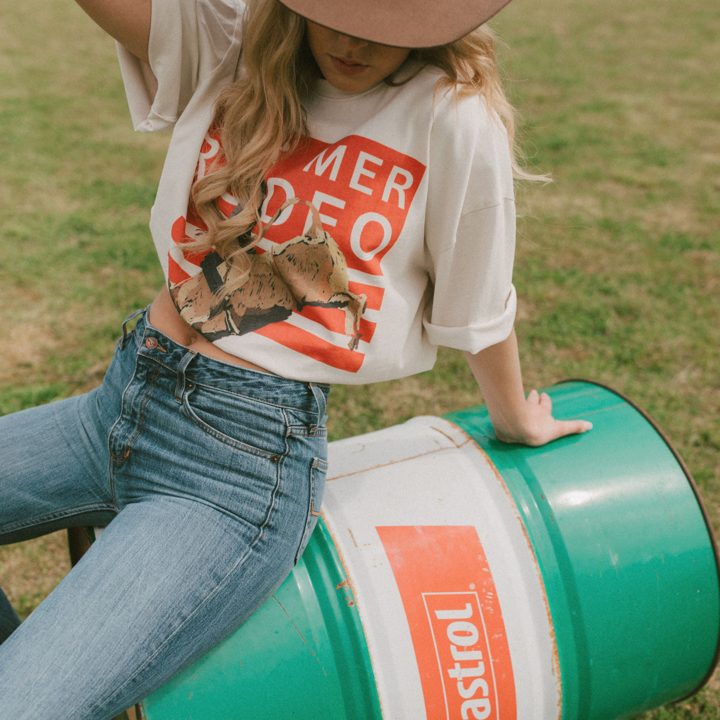 Three-quarter view of Rodeo Box Tee featuring orange rodeo graphic and relaxed fit short sleeves