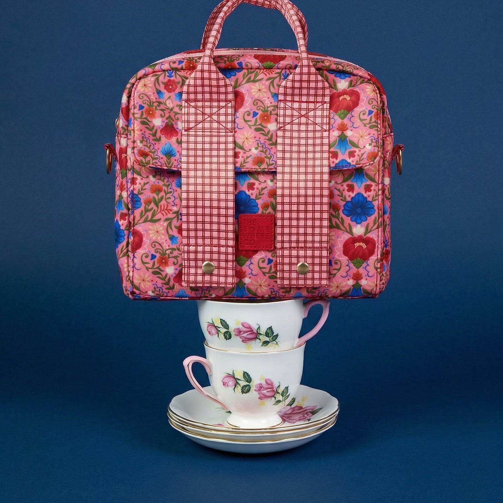 Front view of Fable lunch tote with pink floral and red gingham pattern on blue background