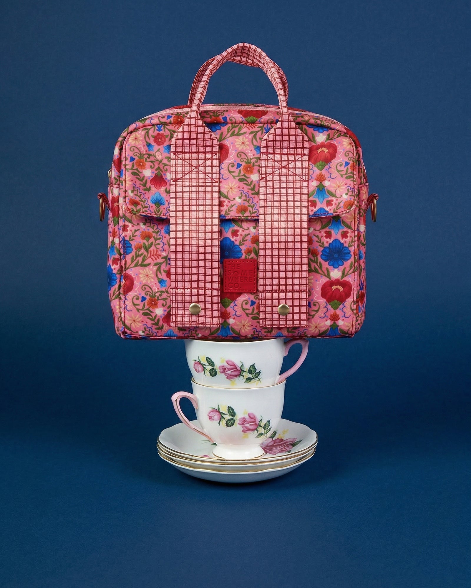 Front view of Fable lunch tote with pink floral and red gingham pattern on blue background