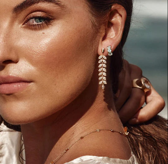 Model wearing blue topaz Huggies earrings from Fairley