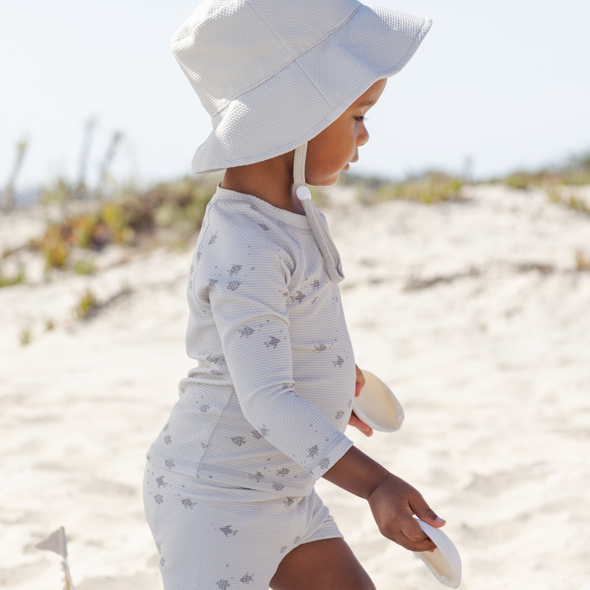 Side view of toddler in the Finn Rashguard + Short Set Fish | Quincy Mae