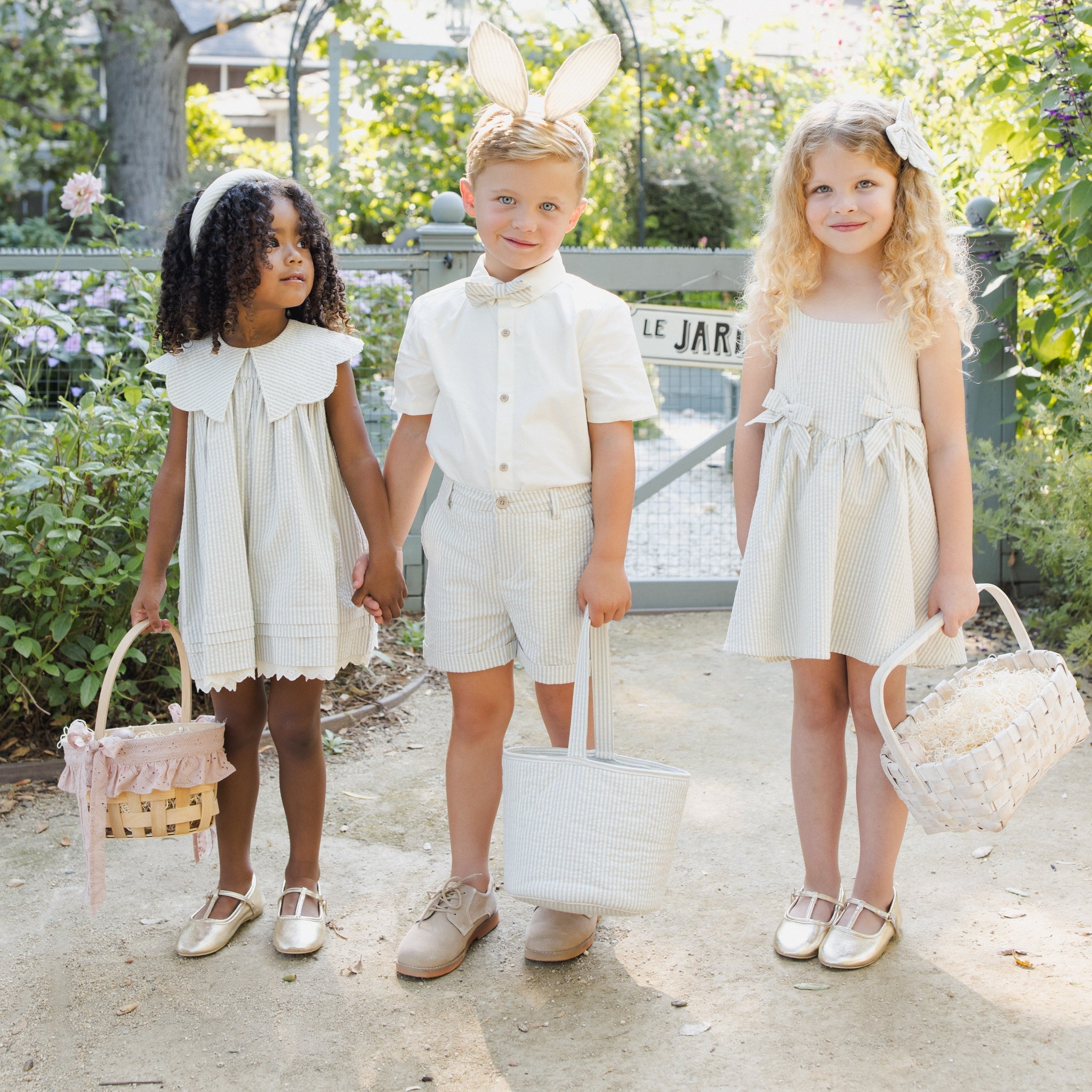 Three children in matching sky stripe outfits showing coordinated collection styling