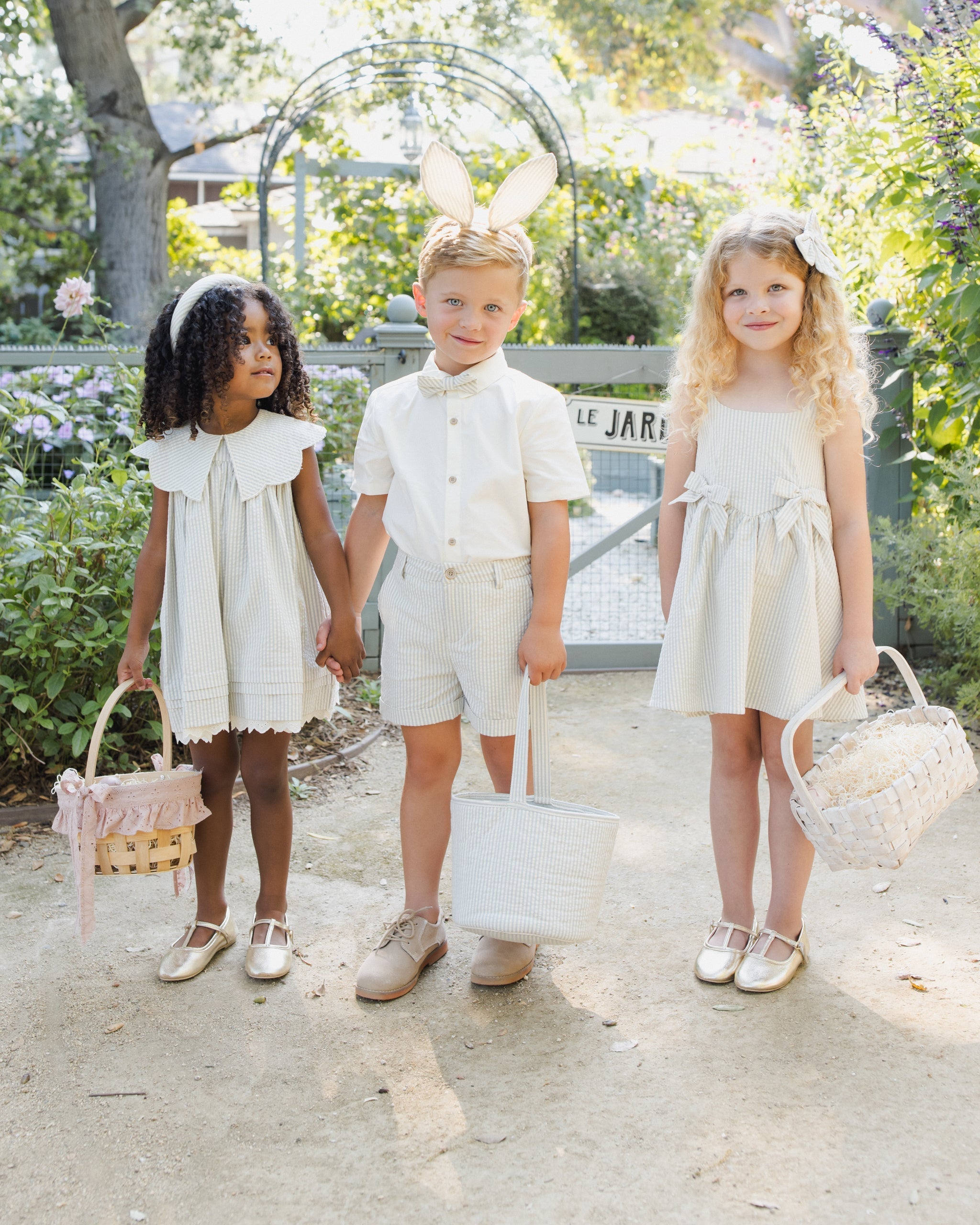 Three children in matching sky stripe outfits showing coordinated collection styling