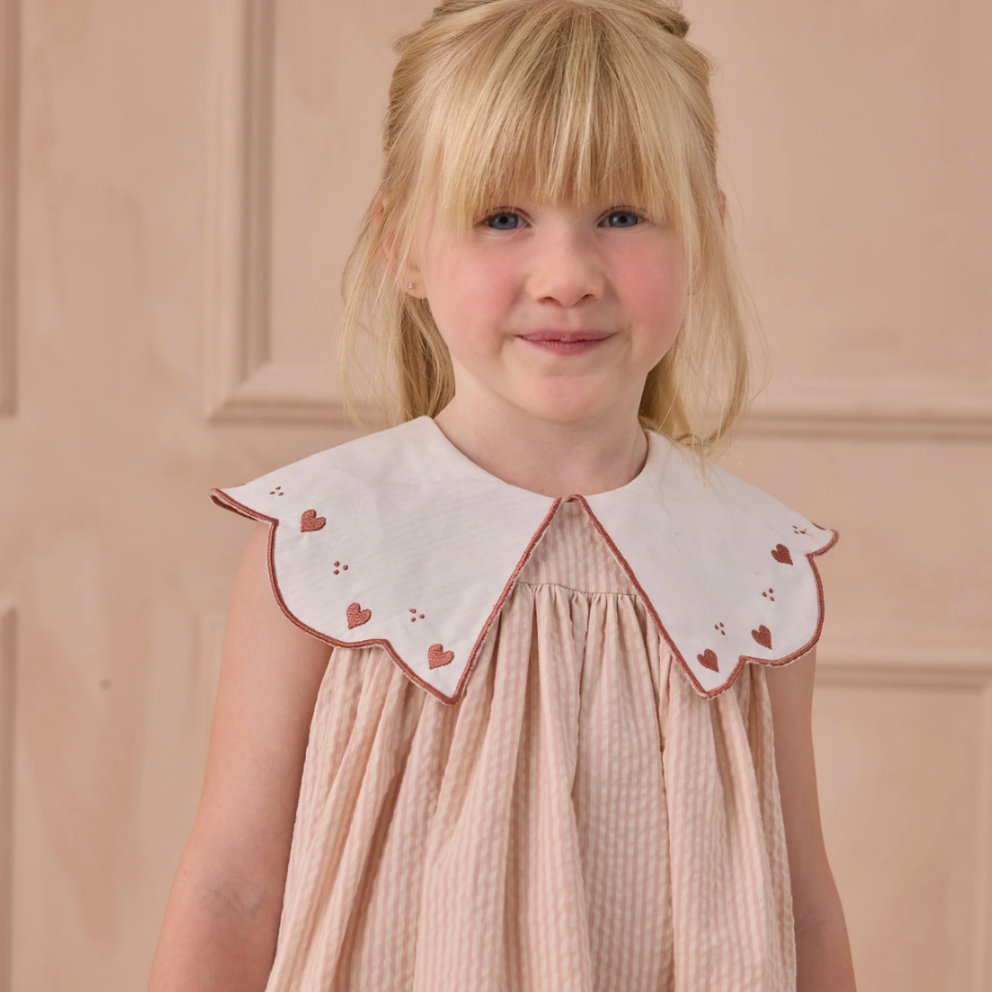 Close up of young girl wearing the Florence Dress - Petal | Noralee
