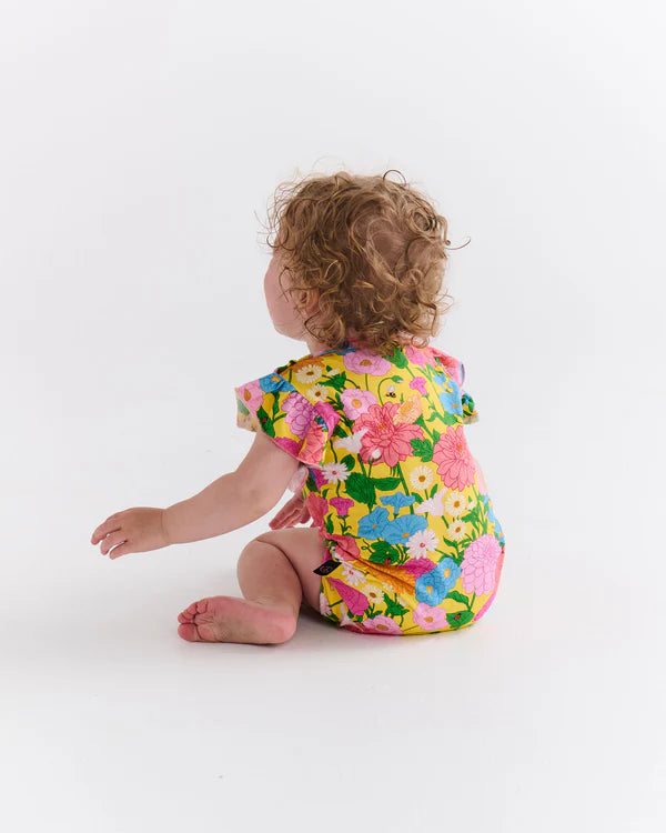 Baby wearing Yellow floral kip & Co Romper