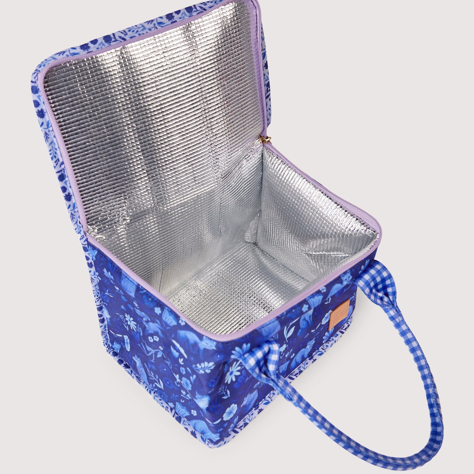 Open lunch bag showing insulated silver interior lining with food items and gingham handles