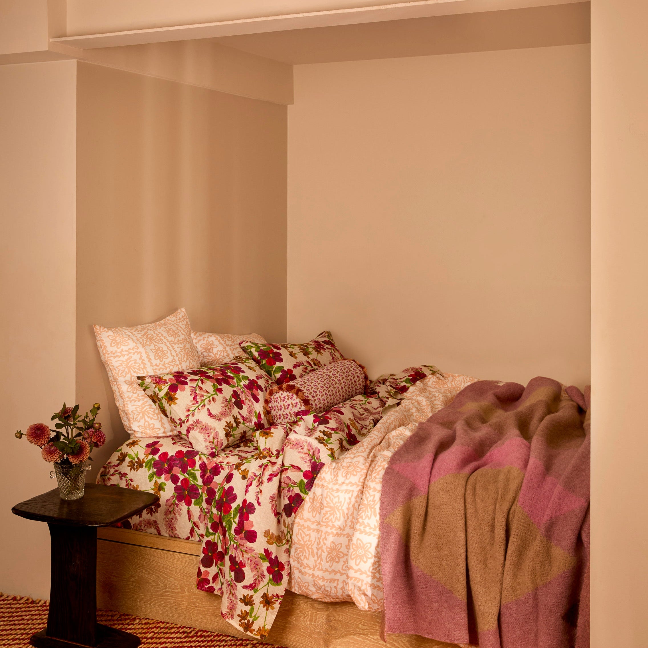 Geometric Pink Mohair Throw draped over wooden bed frame in cozy bedroom setting
