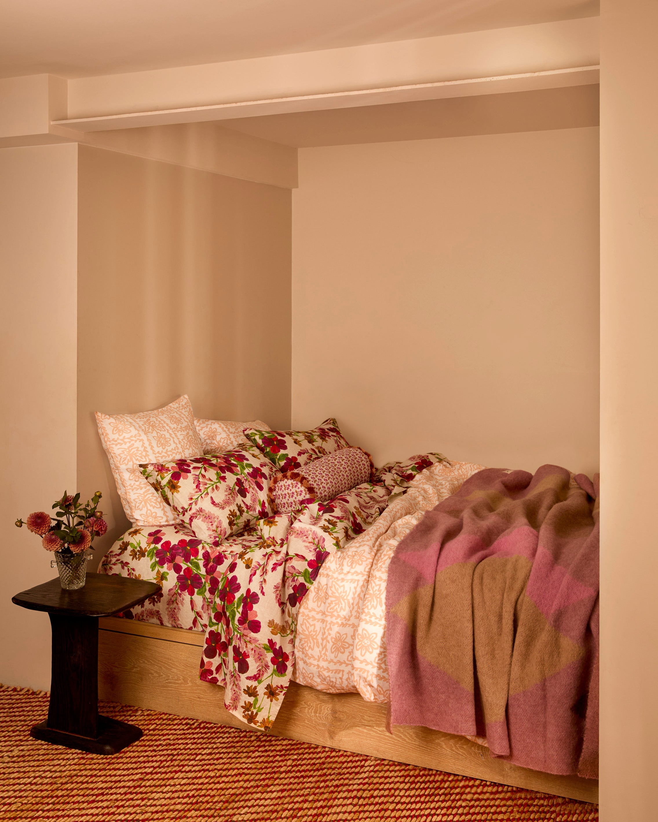 Geometric Pink Mohair Throw draped over wooden bed frame in cozy bedroom setting