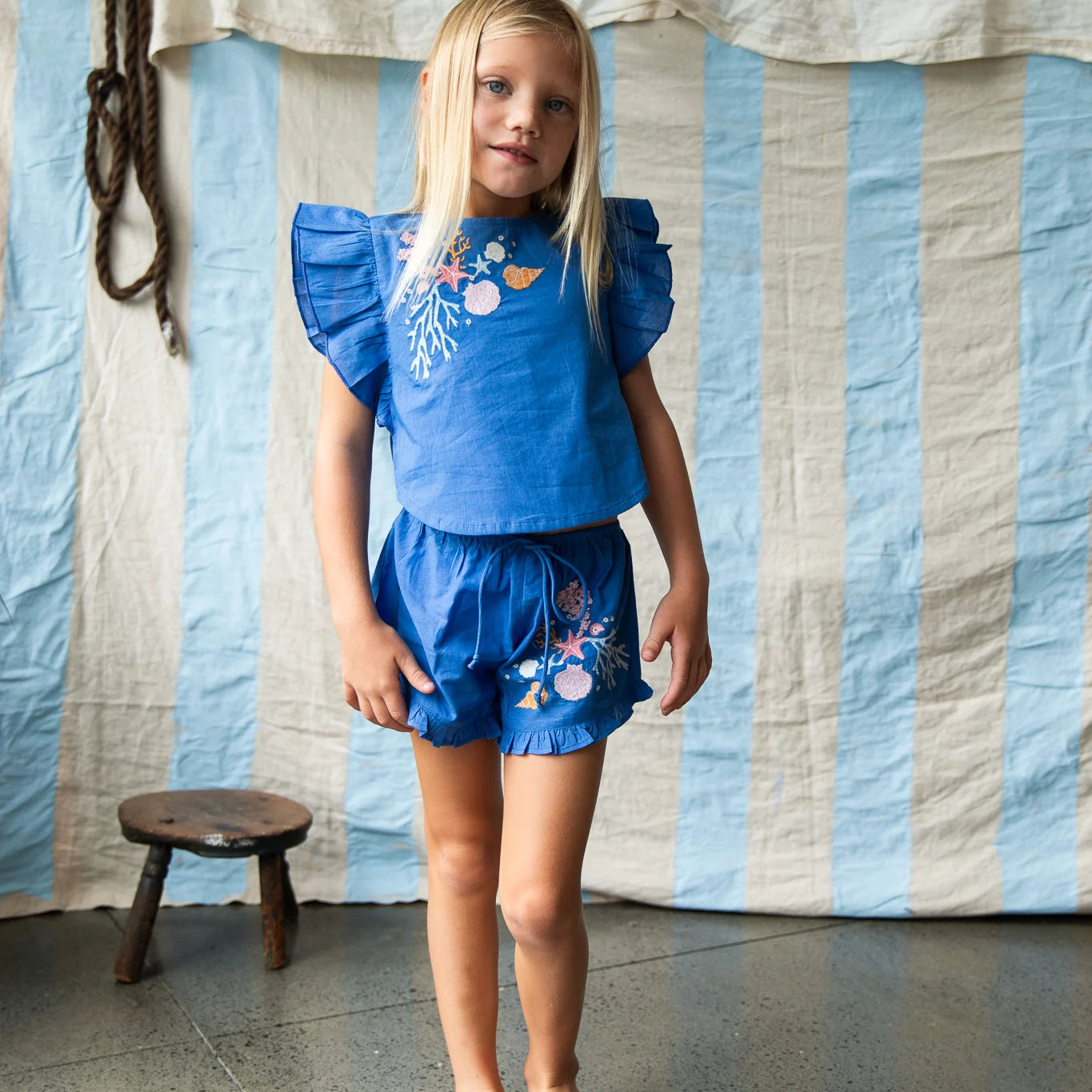 Girl wearing blue shorts with coral embroidery by Pearson and Pearson
