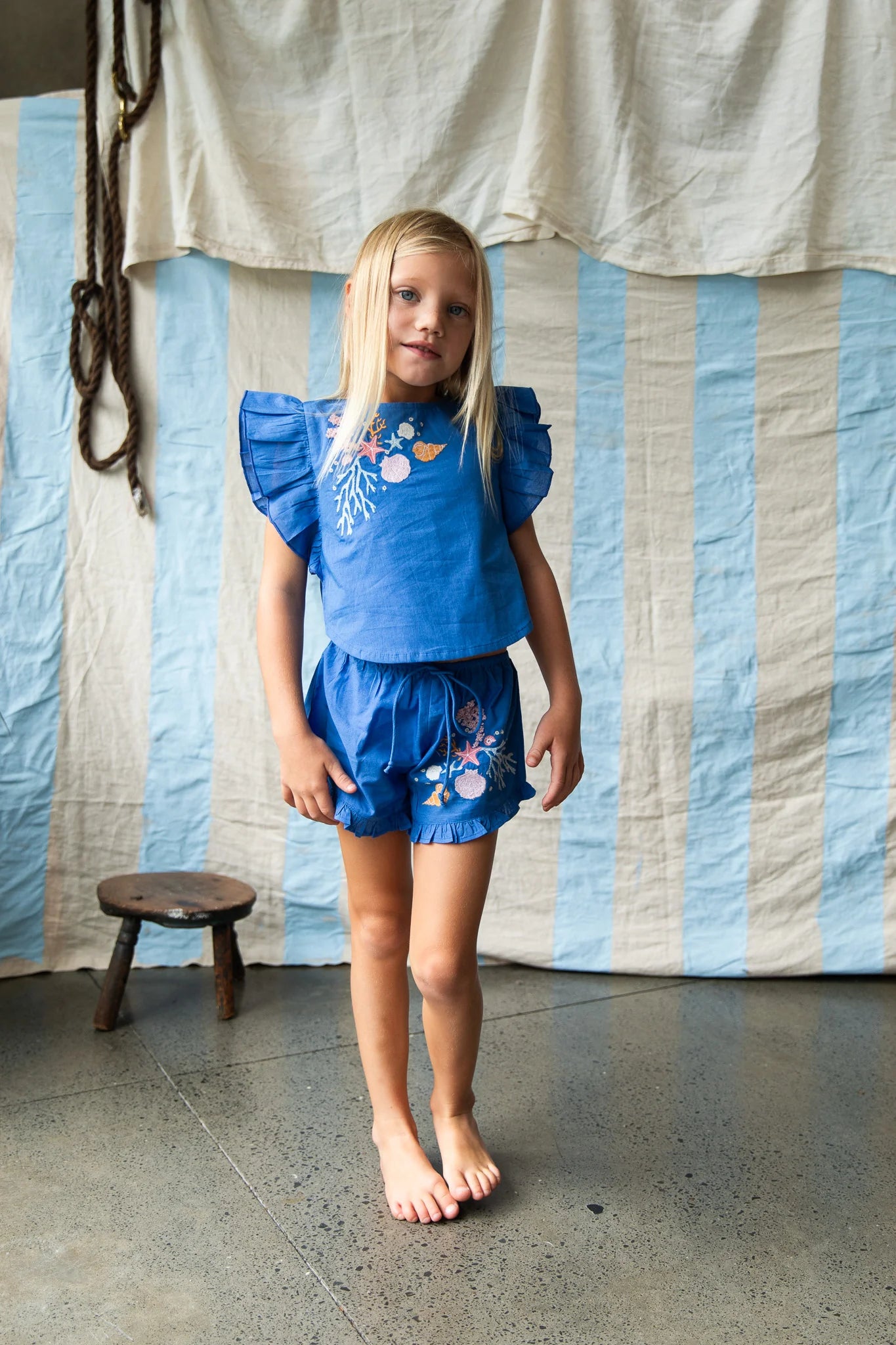Girl wearing blue shorts with coral embroidery by Pearson and Pearson