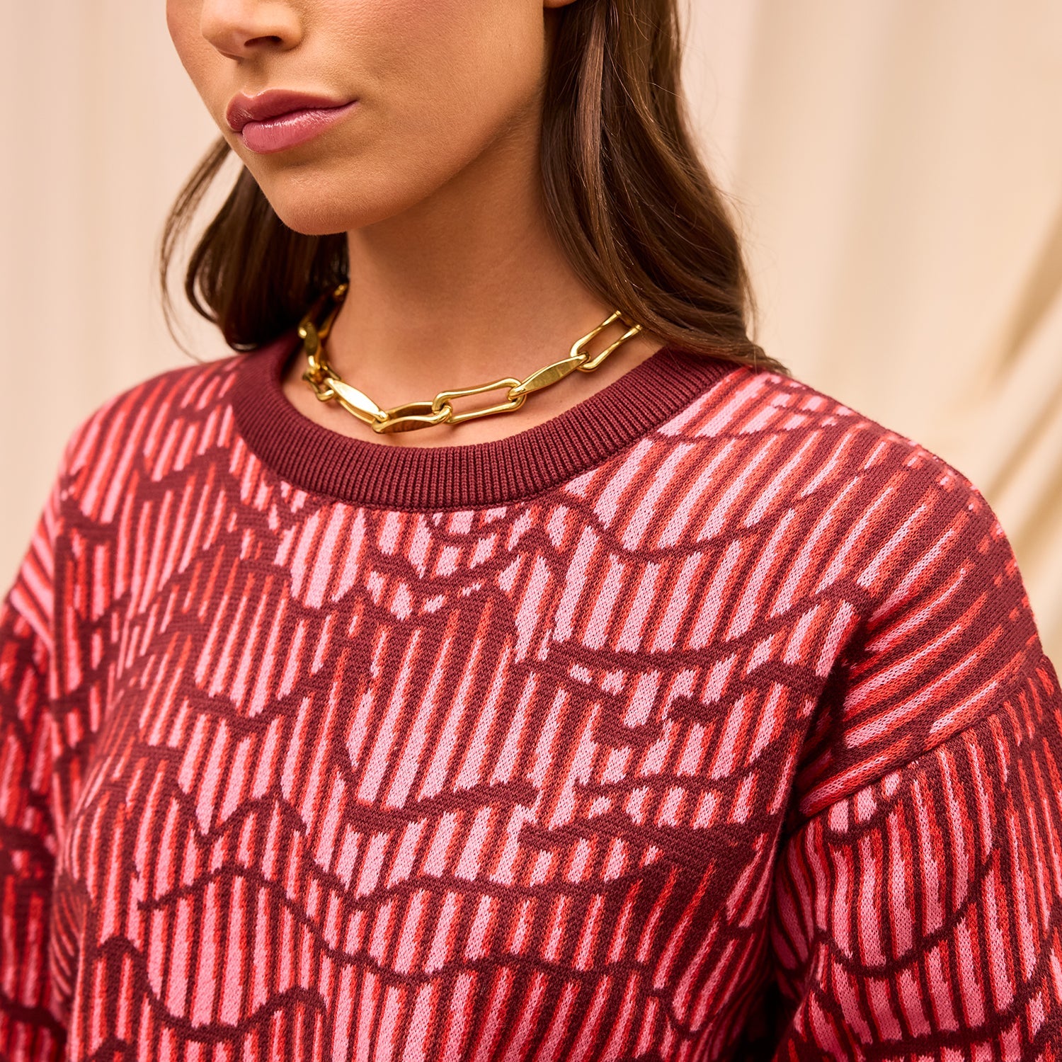 Close-up detail of Hanna Knit Sweater neckline showing red geometric pattern and ribbed trim