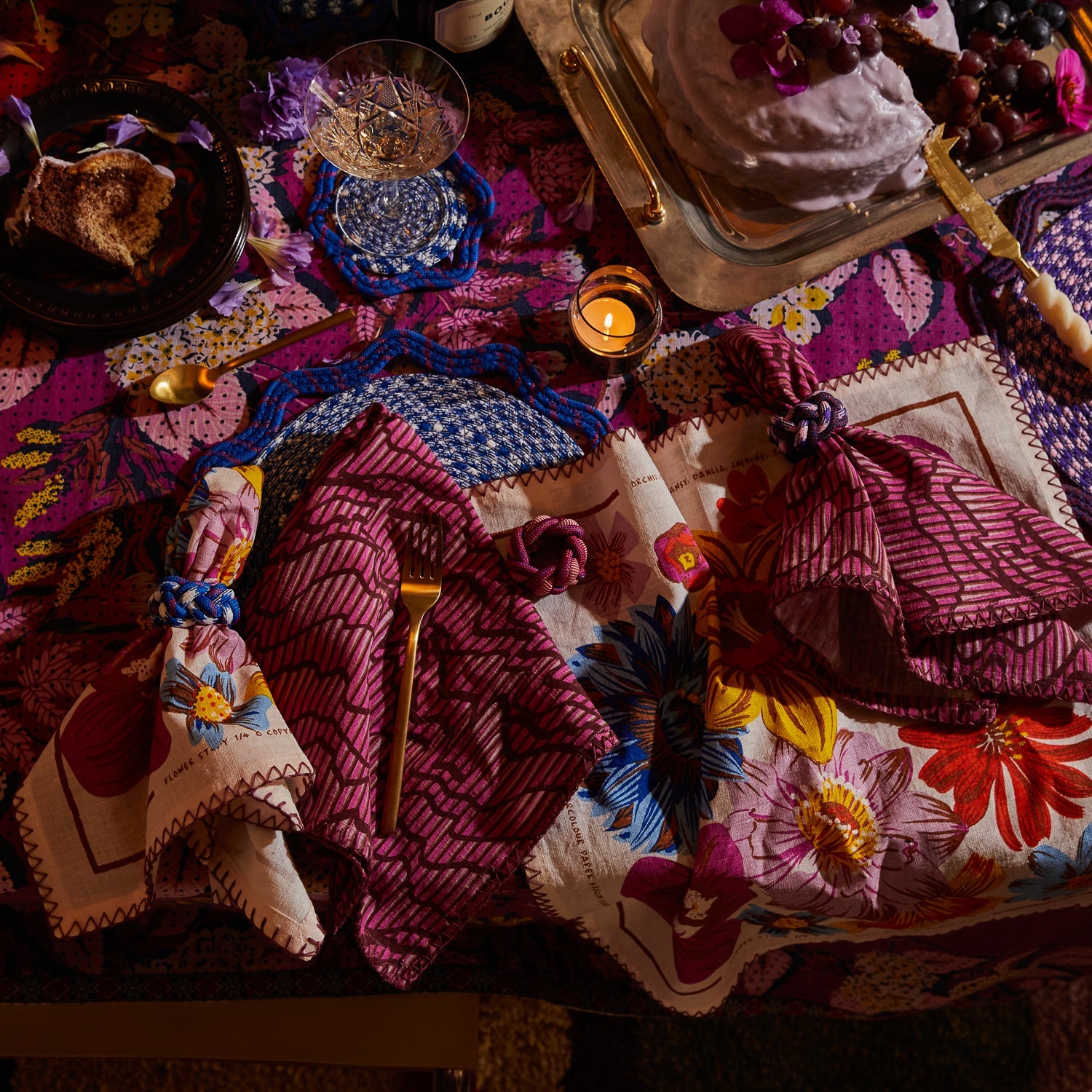 Overhead view of Hanna Pansy napkin set arranged on tablescape with colorful floral patterns and zigzag stitching