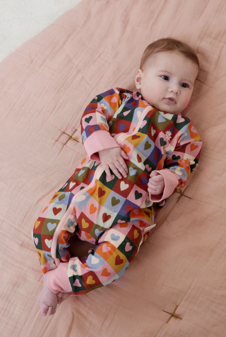 Baby wearing the multi-coloured Heart Checkerboard Zip All In One | Kapow Kids