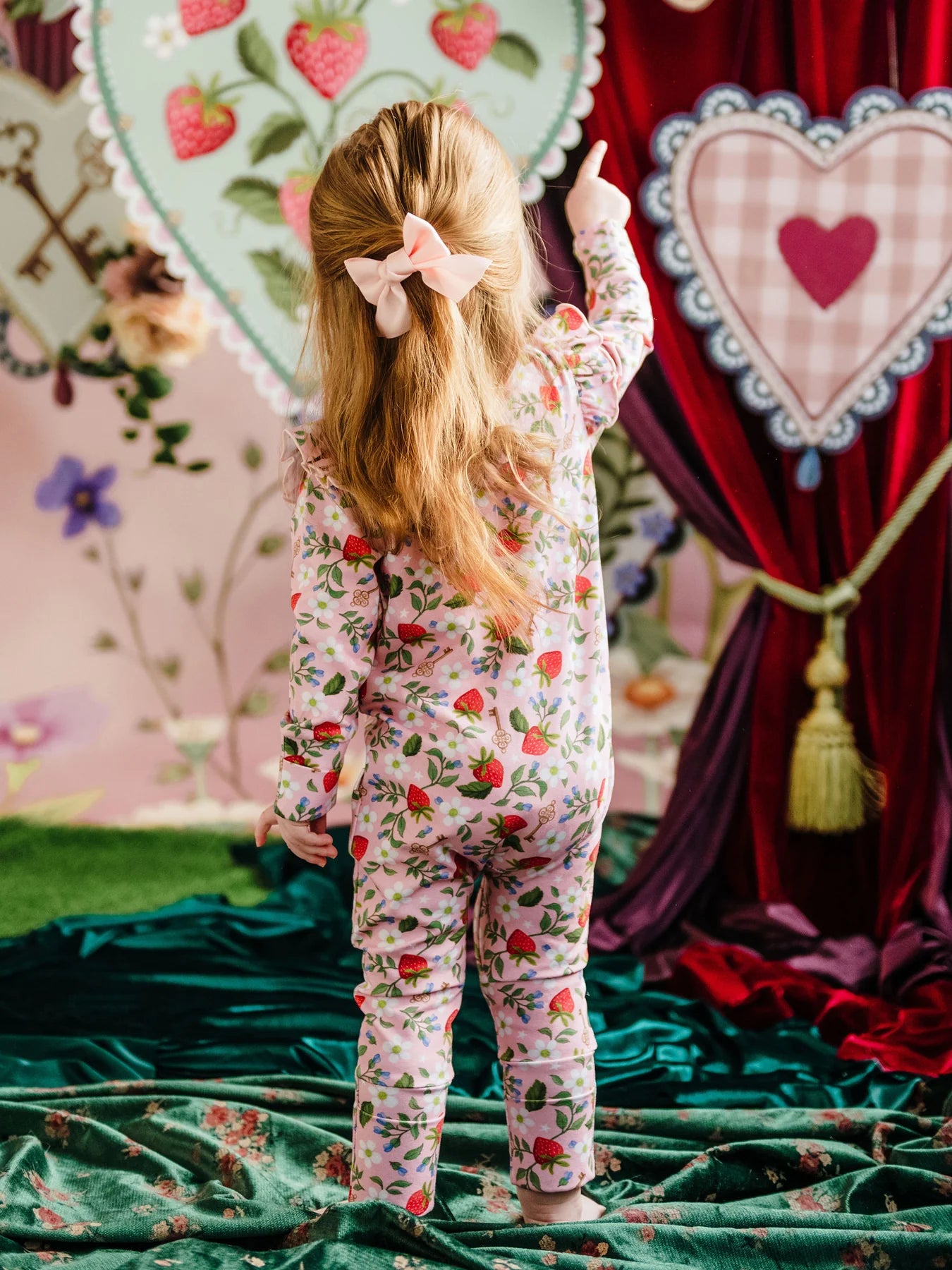 toddler wearing the a pink strawberry onesie by Fleur Harris