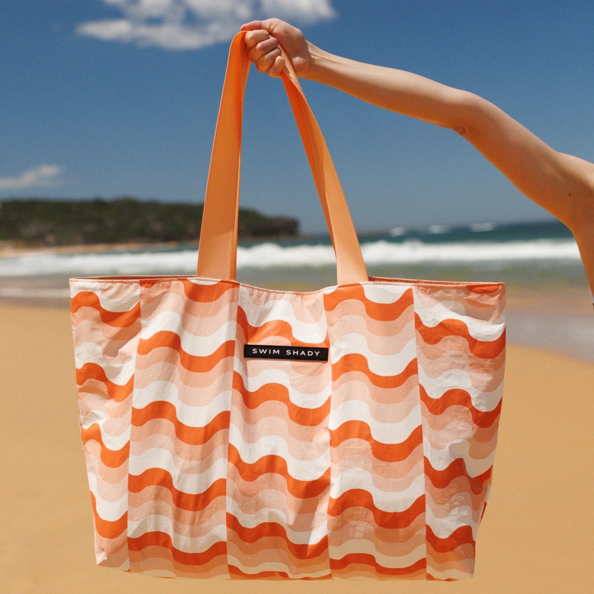 Swim Bag Heat by Swim Shady with orange and white wave design and internal pockets