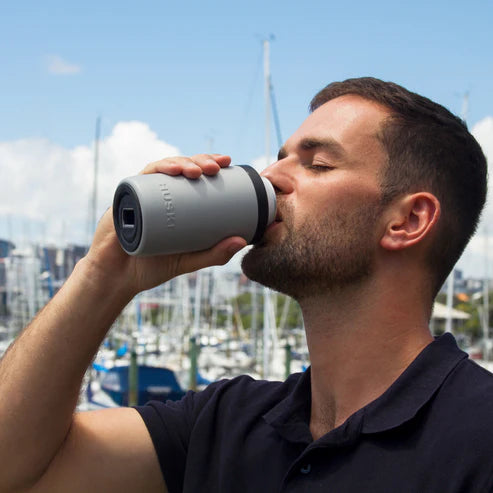 Man drinking from Huski Beer Cooler in Stone Grey