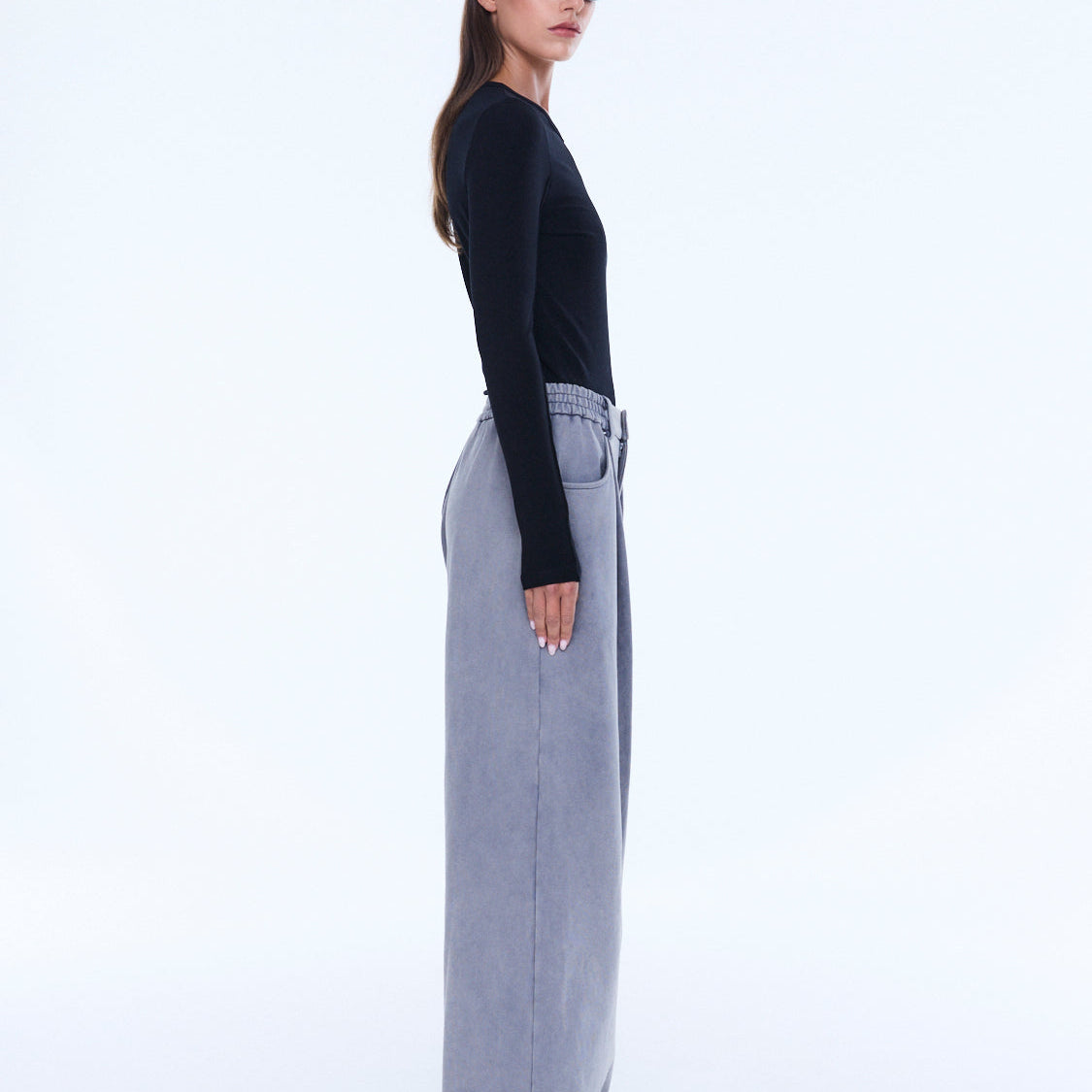 Side profile view of dove grey jersey wide leg pants showing relaxed fit and styling
