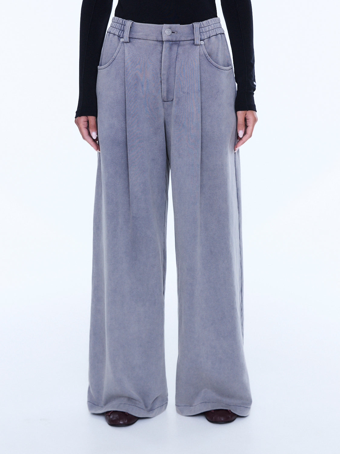 Front view detail of dove grey jersey pants showing button closure and wide leg silhouette