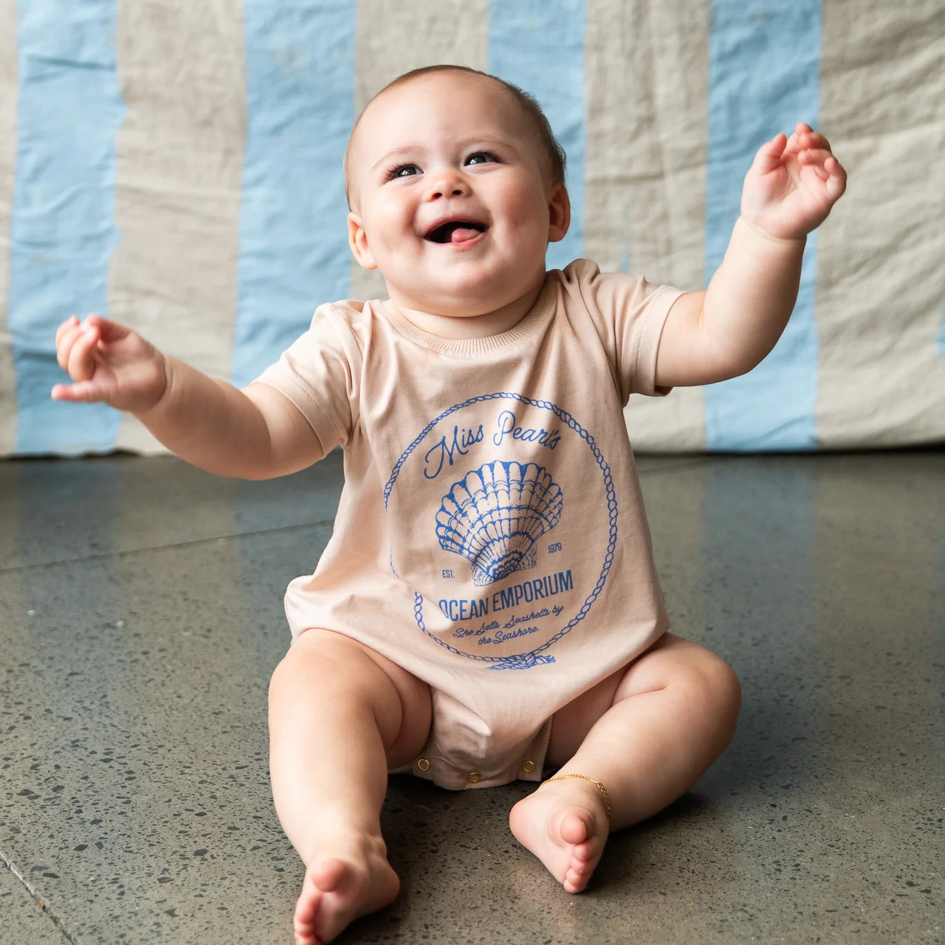 Baby wearing cream onesie with blue shell graphic - Indi Romper - Sand by Pearson & Pearson