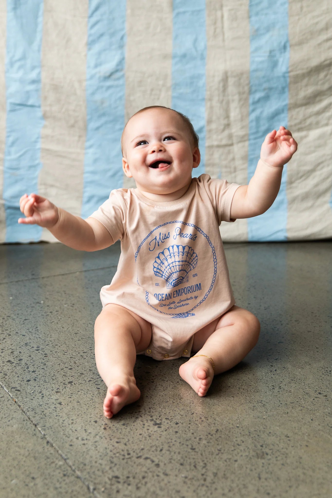 Baby wearing cream onesie with blue shell graphic - Indi Romper - Sand by Pearson & Pearson