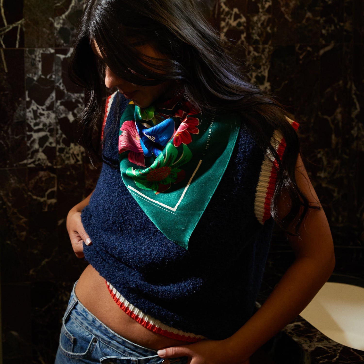 Model looking down wearing Ines Silk Scarf as neck accessory highlighting the luxurious silk drape and floral design