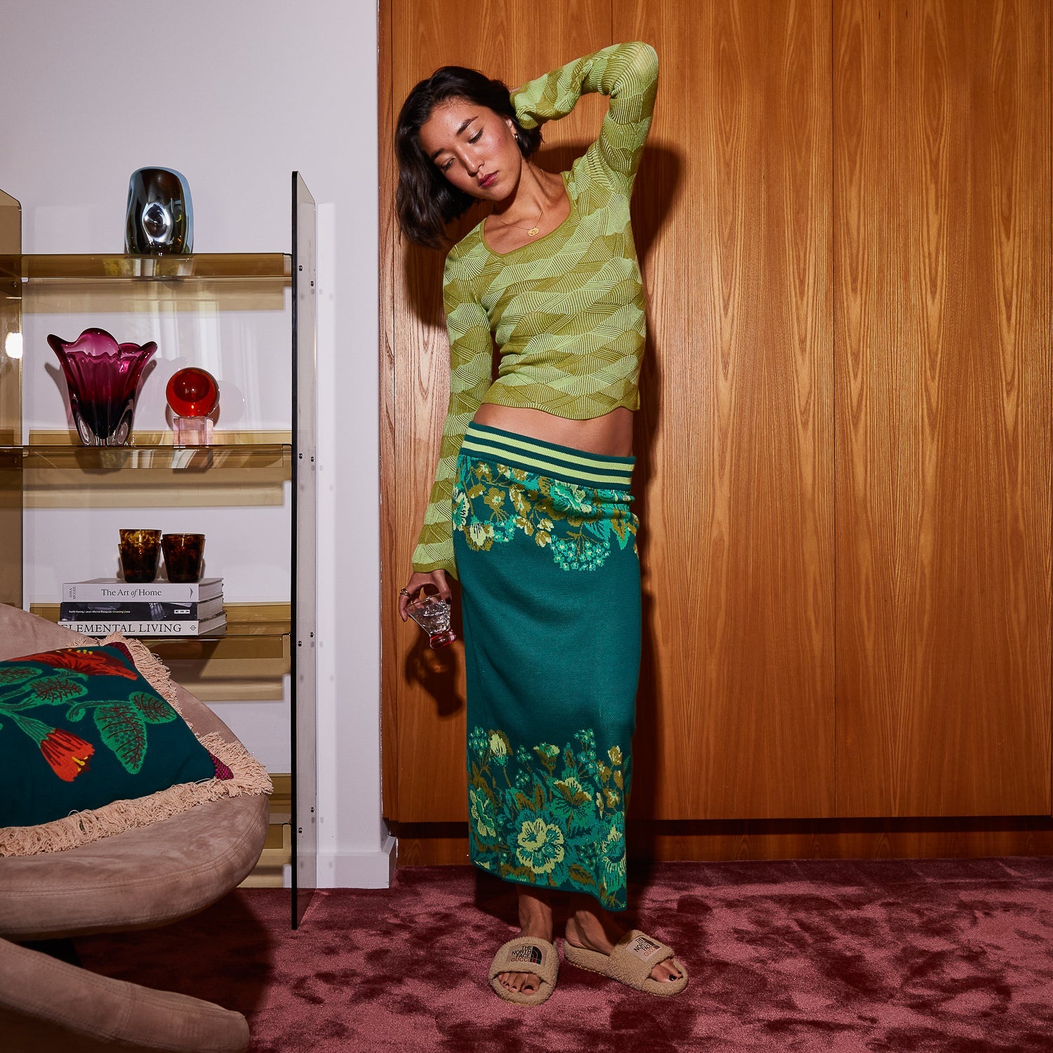 Woman wearing juniper green merino wool knit top with square neckline and flared sleeves