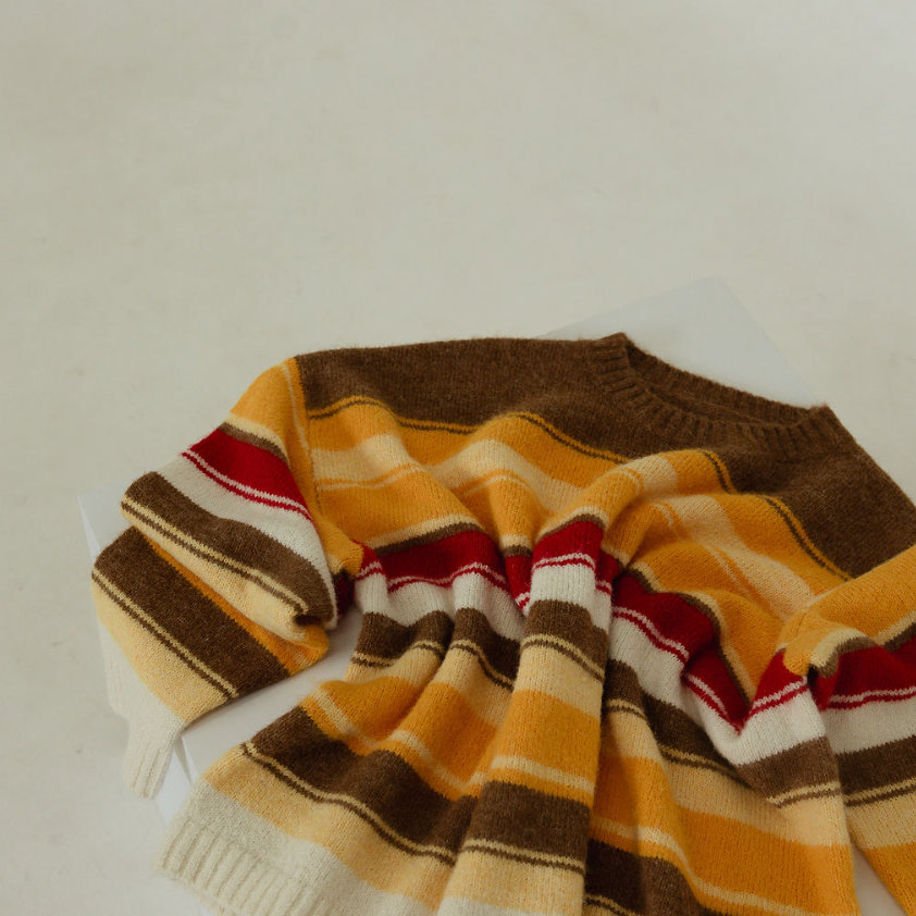 Flat lay of Isabel Knit sweater showing autumn stripe pattern detail with brown yellow red cream stripes