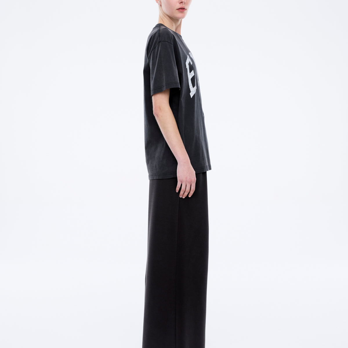 Side profile view showing oversized fit and dropped shoulders of Jessie collegiate tee in charcoal
