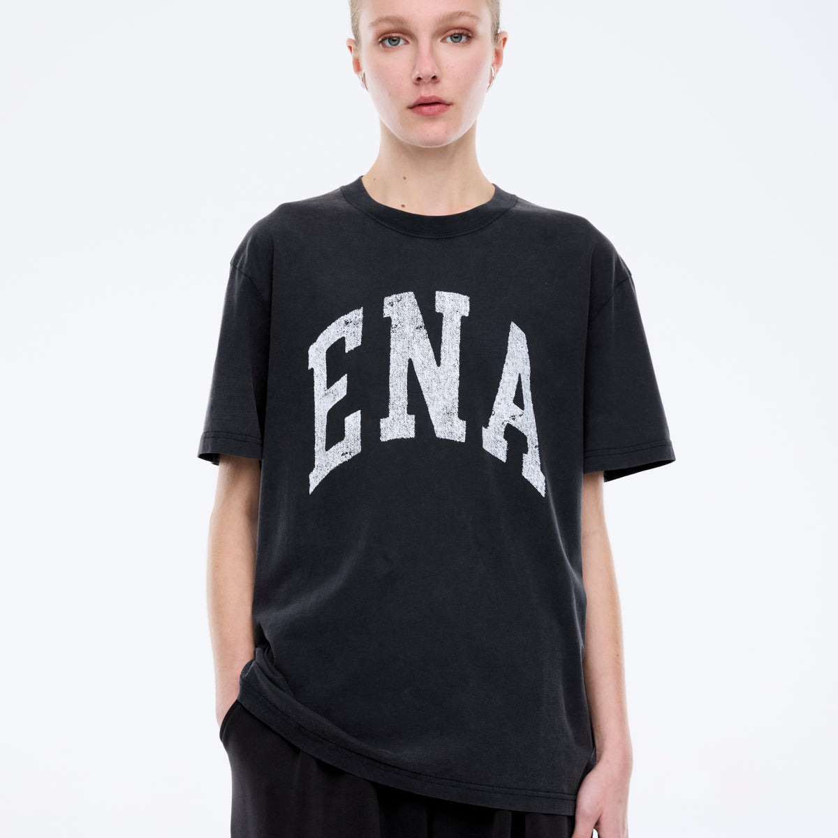 Front detail of Jessie collegiate tee featuring distressed white ENA lettering on charcoal cotton