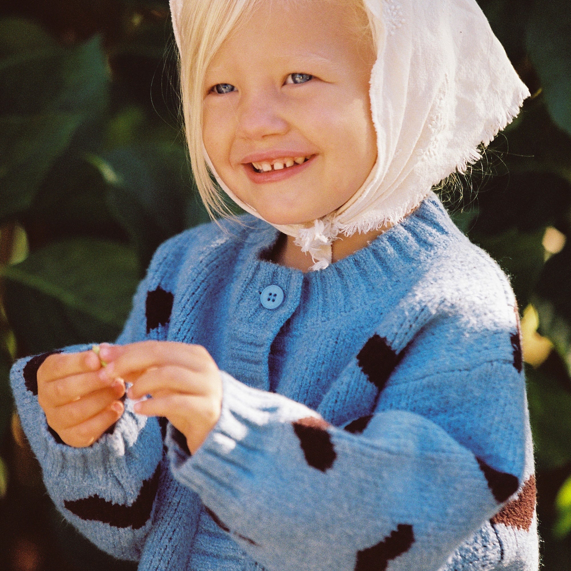 Girl wearing Juni patterned knit cardigan with heart design Australia