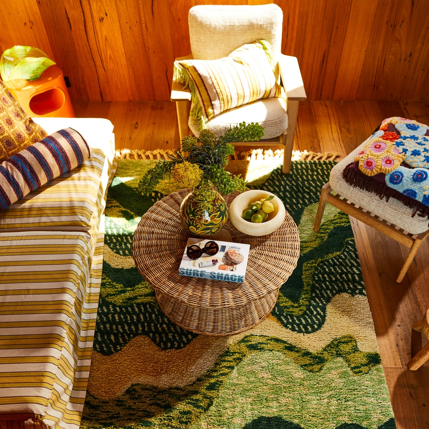 Overhead room view of cream marbled resin Jeanne Bowl with fruit on wicker coffee table in boho living room