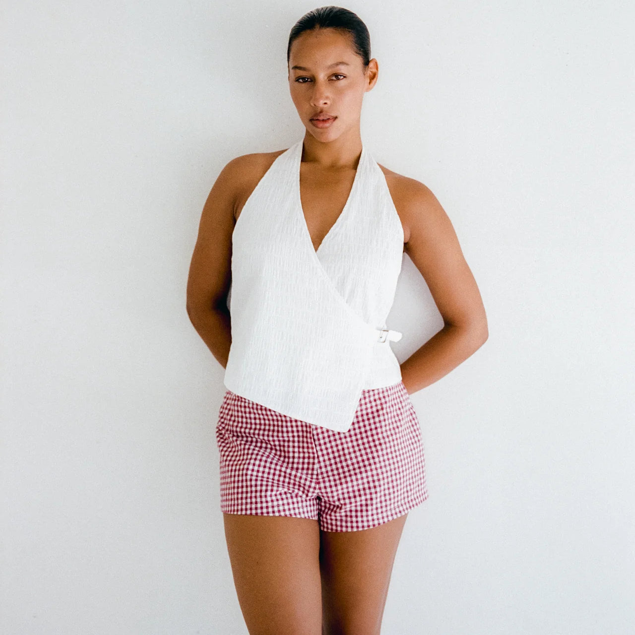 Model wearing red and white June Tailored Short - Cherry Gingham by Juni