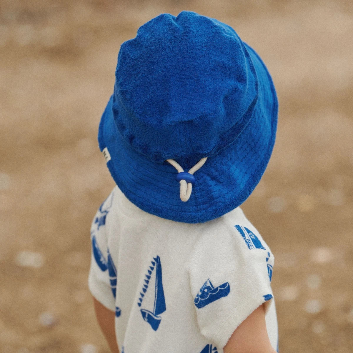 child wearing Juno Romper Terry Regatta Print by Nature Baby