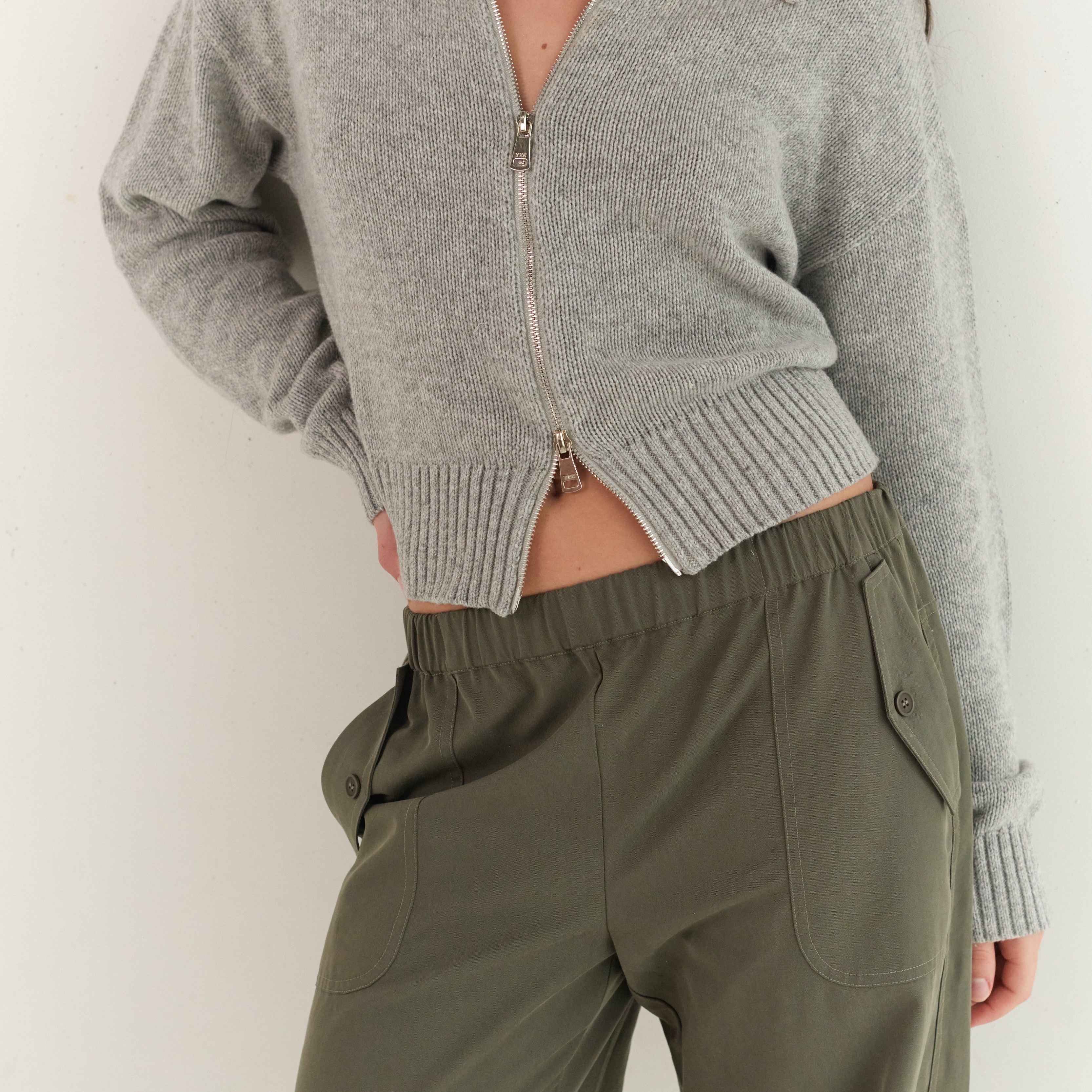 Close-up front view of stone grey Kaia Zip Cardigan showing knit texture and zip detail